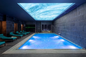 Indoor swimming pool with blue illuminated ceiling