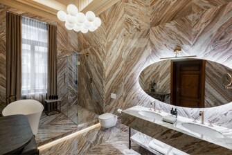 A marble bathroom with a shower and a bathtub.