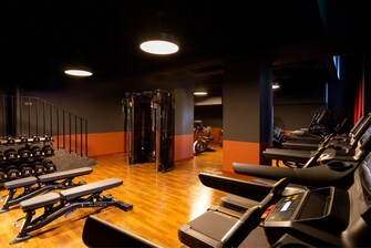 Dimmed, fully equipped fitness room.