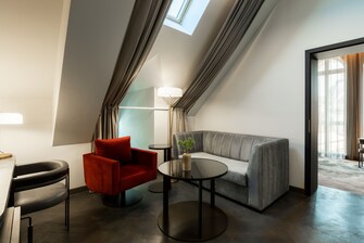 Una habitación espaciosa con una silla y un sofá.