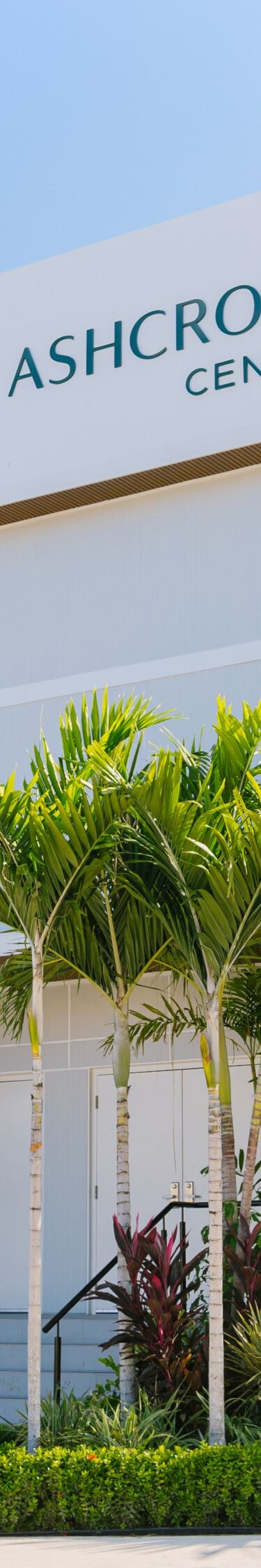 White venue exterior with palm trees