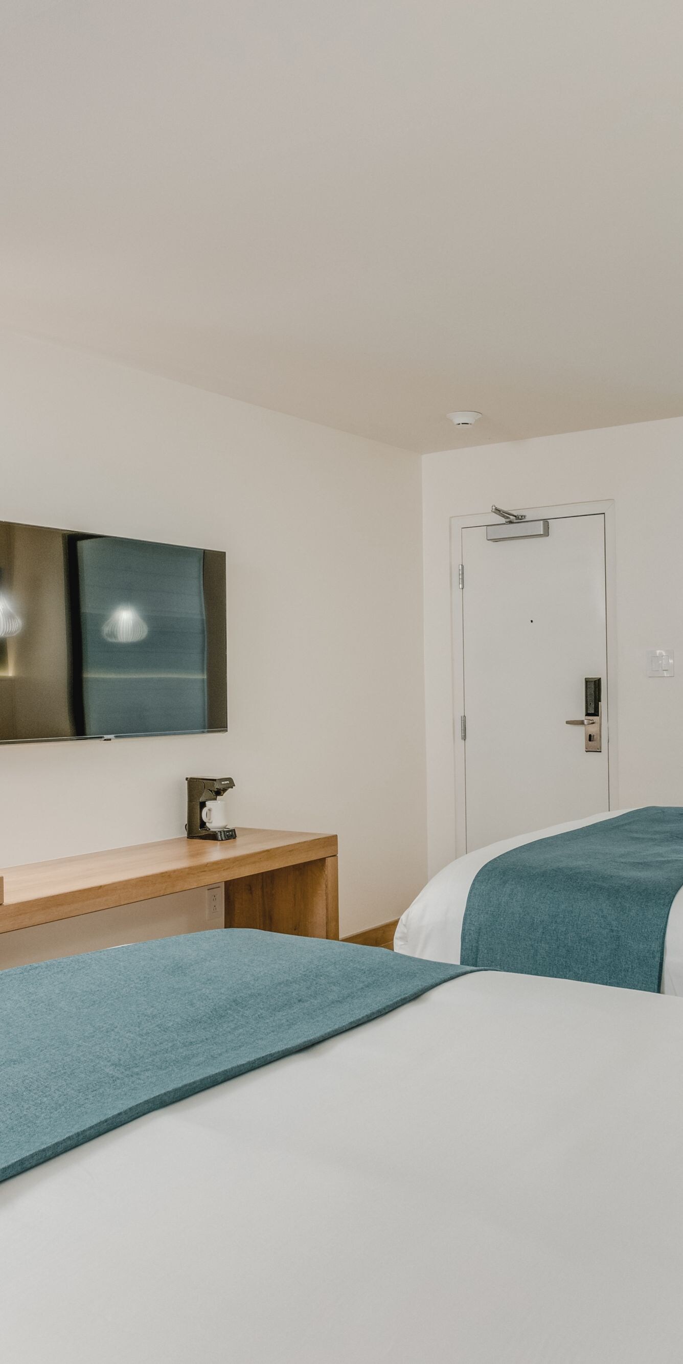 Two queen beds with desk and TV