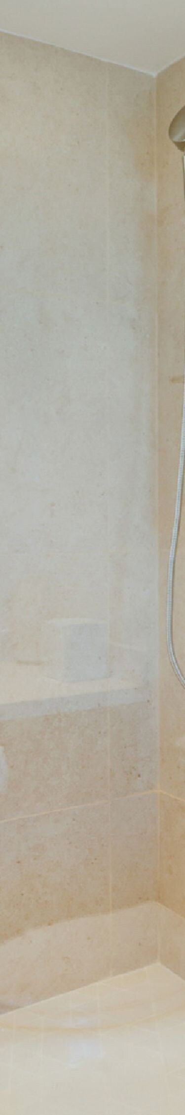 Glass shower with beige tile
