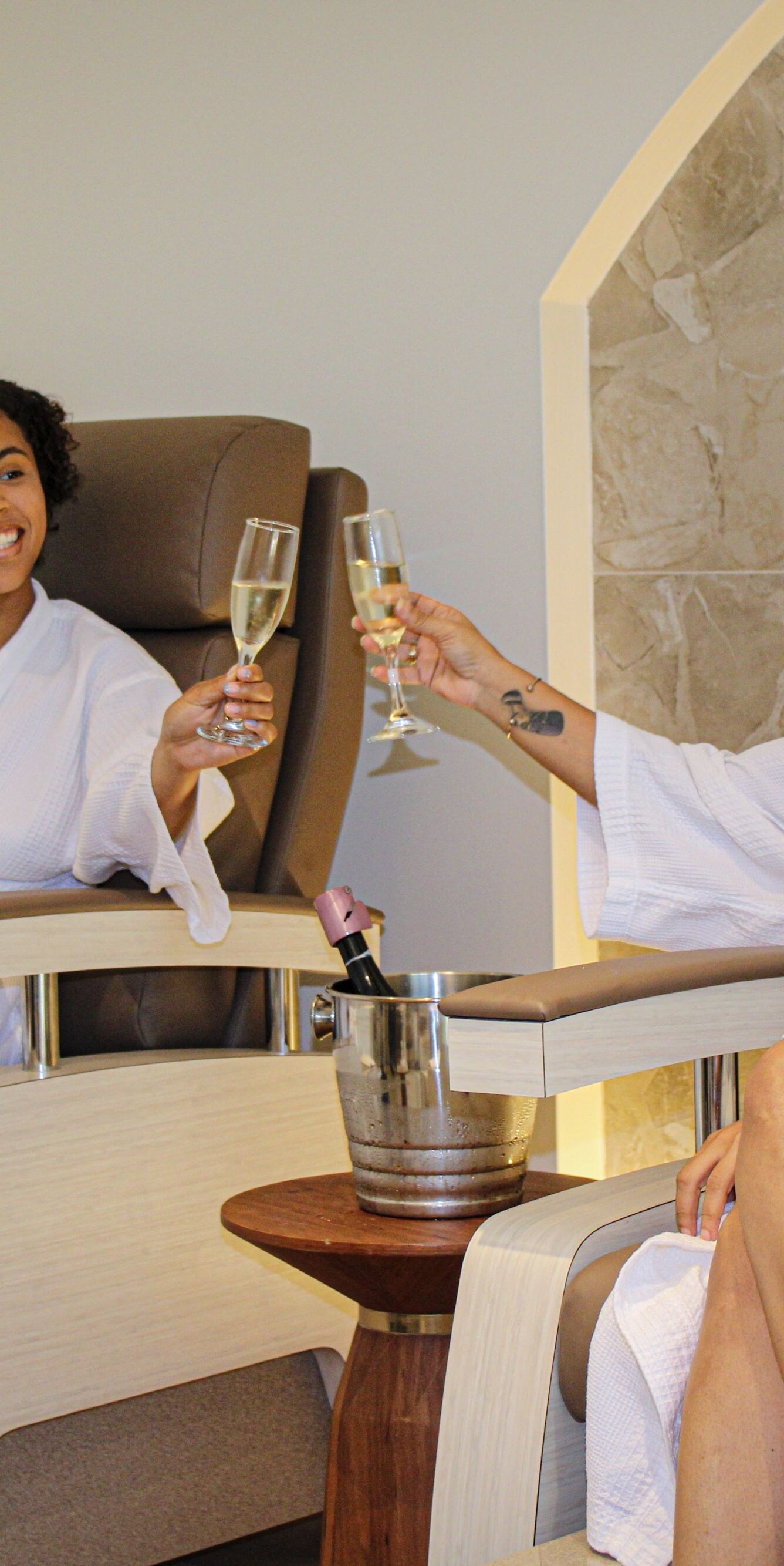 Two people toasting in spa chairs