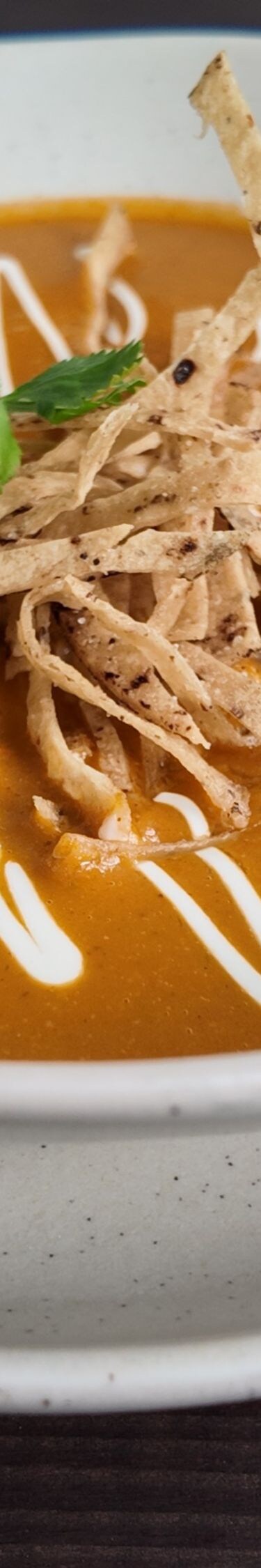 Bowl of tortilla soup with toppings