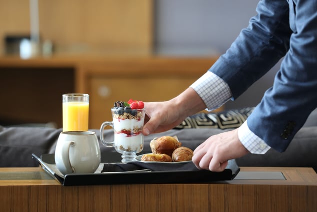 Hands placing tray with breakfast items down 