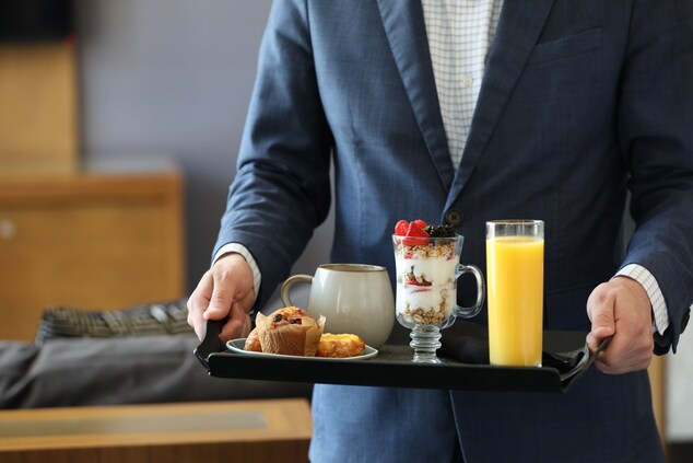 Man Holding a tray with breakfast items