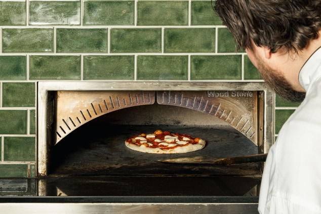 Pizza cooking in brick oven