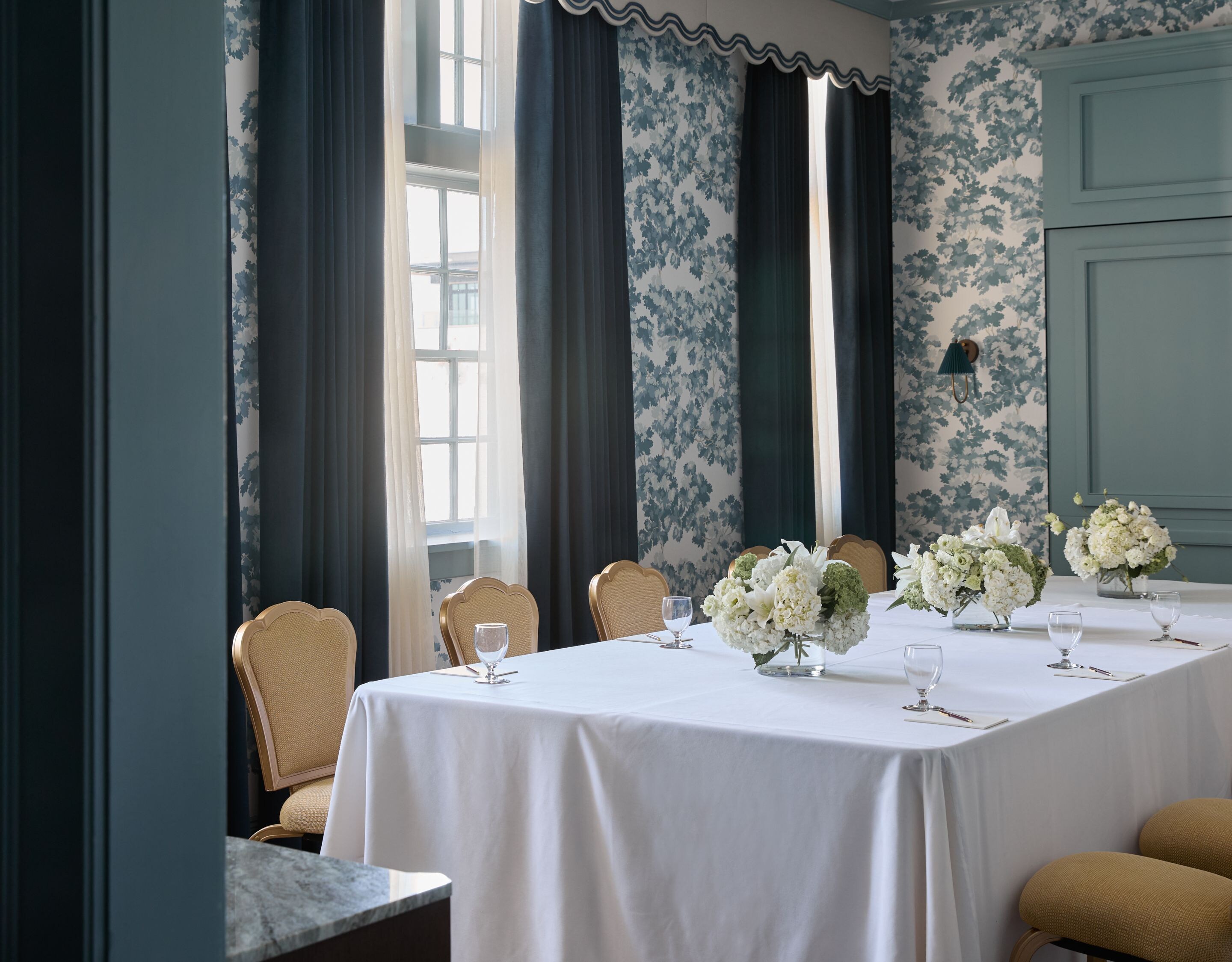 Boardroom with floral centerpieces & tall windows