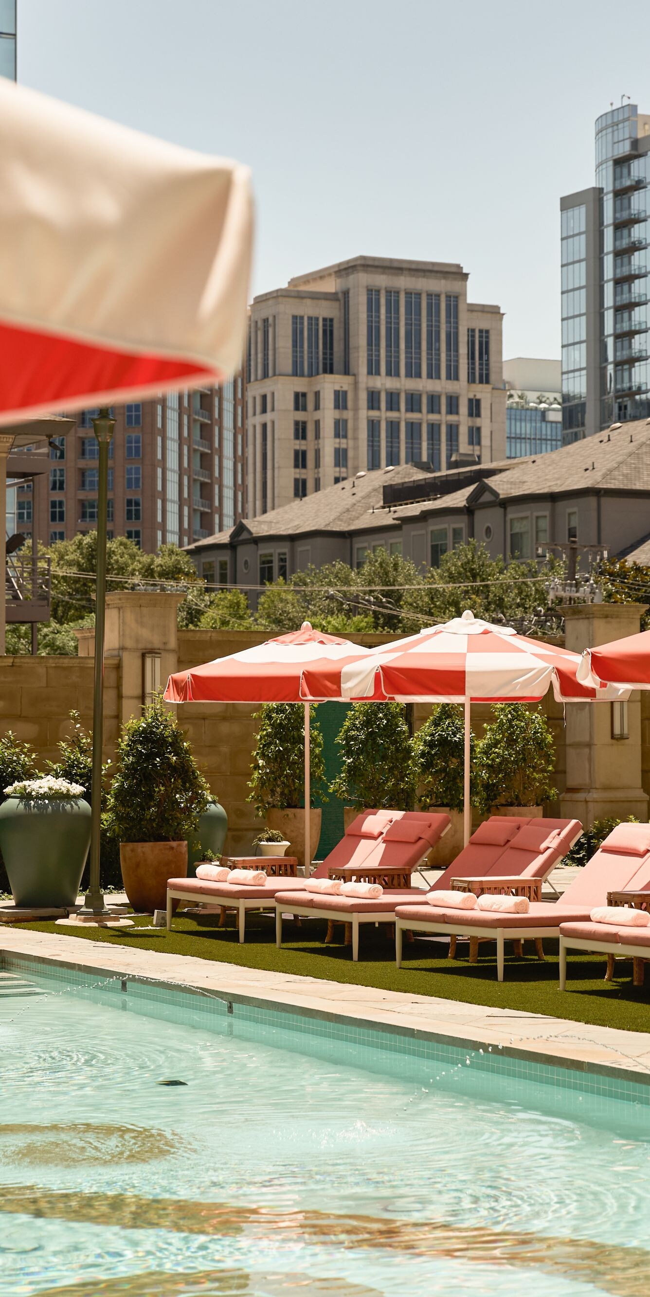 Outdoor pool with loungers and striped umbrellas