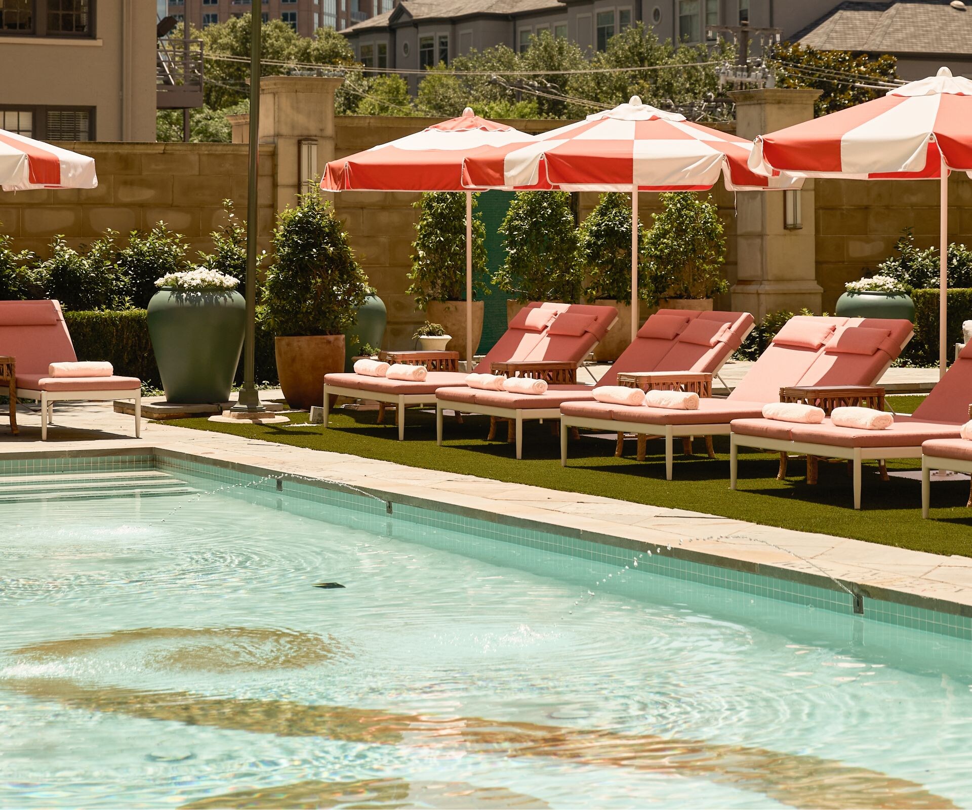 Outdoor pool with loungers and striped umbrellas