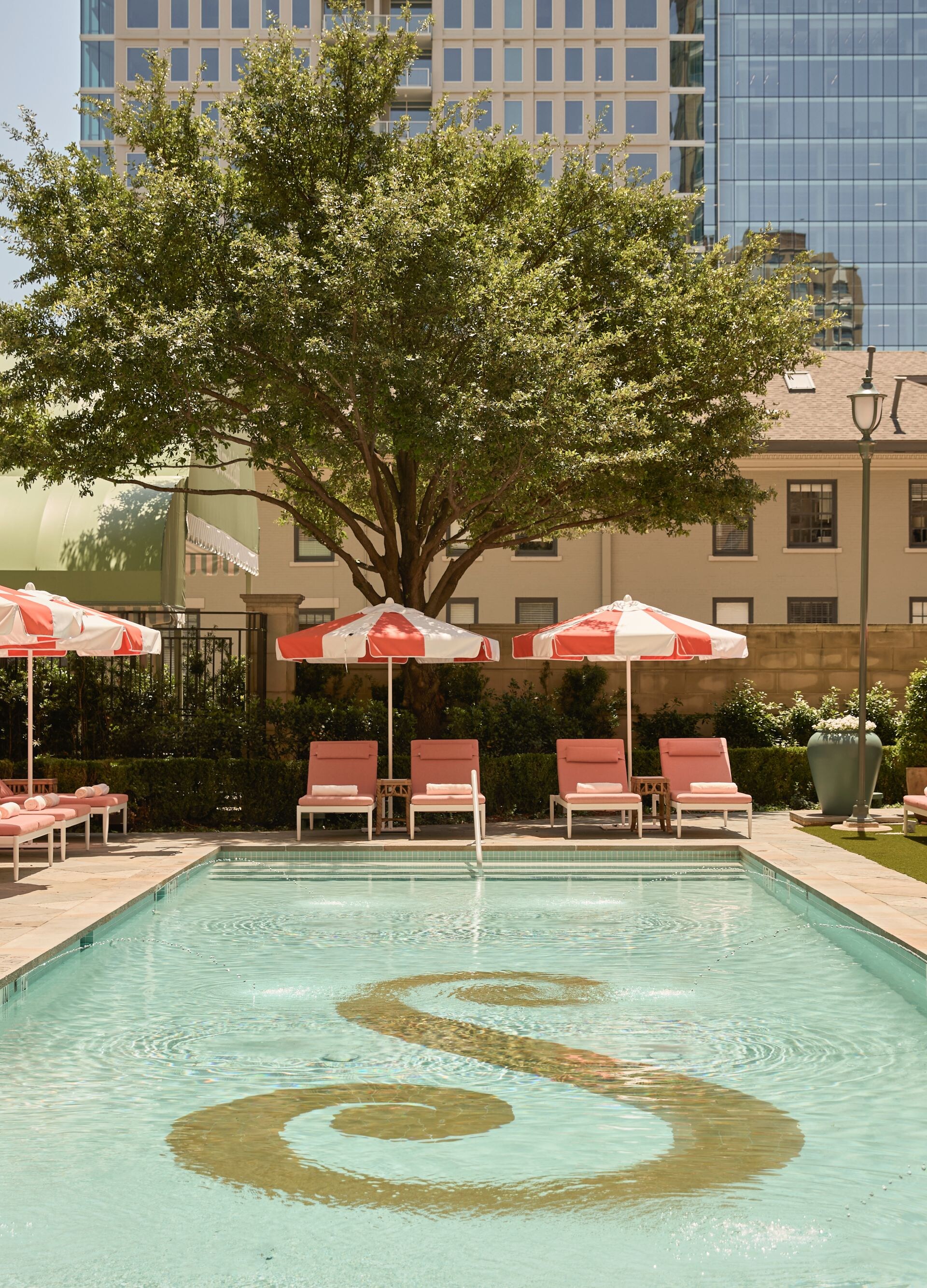 Outdoor pool with loungers and red umbrellas