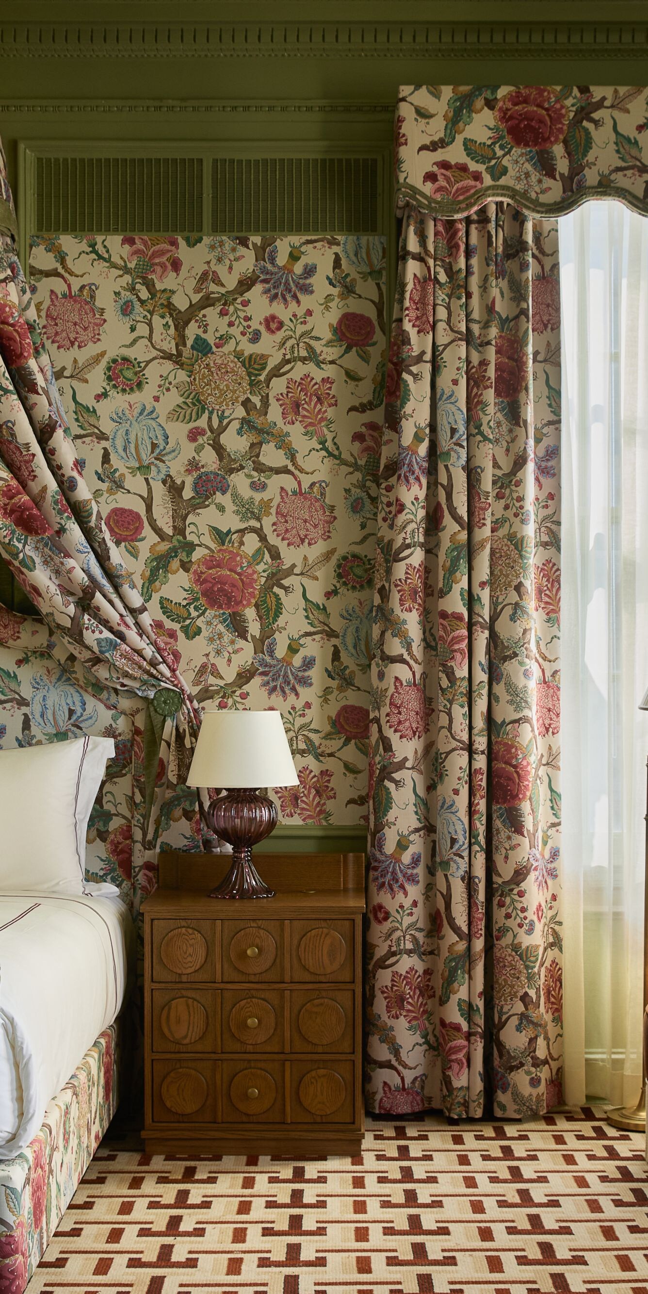 Bedroom with floral canopy bed and seating area