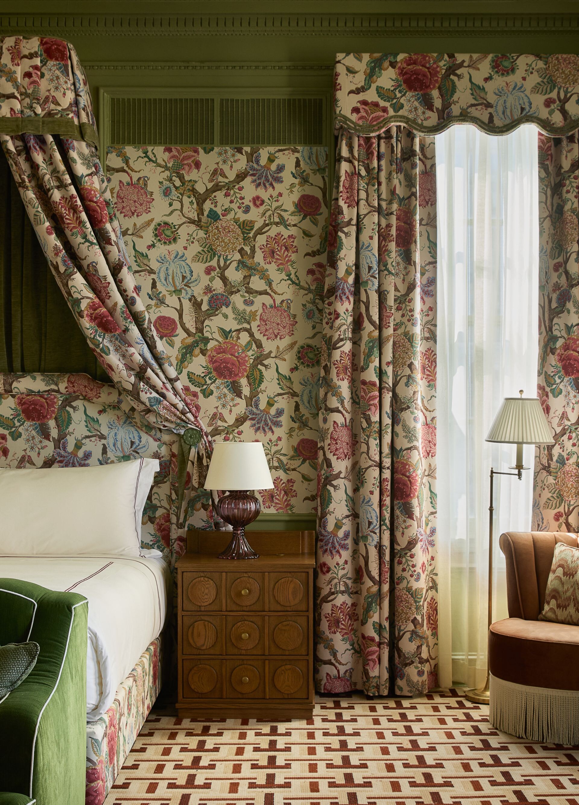 Bedroom with floral canopy bed and seating area