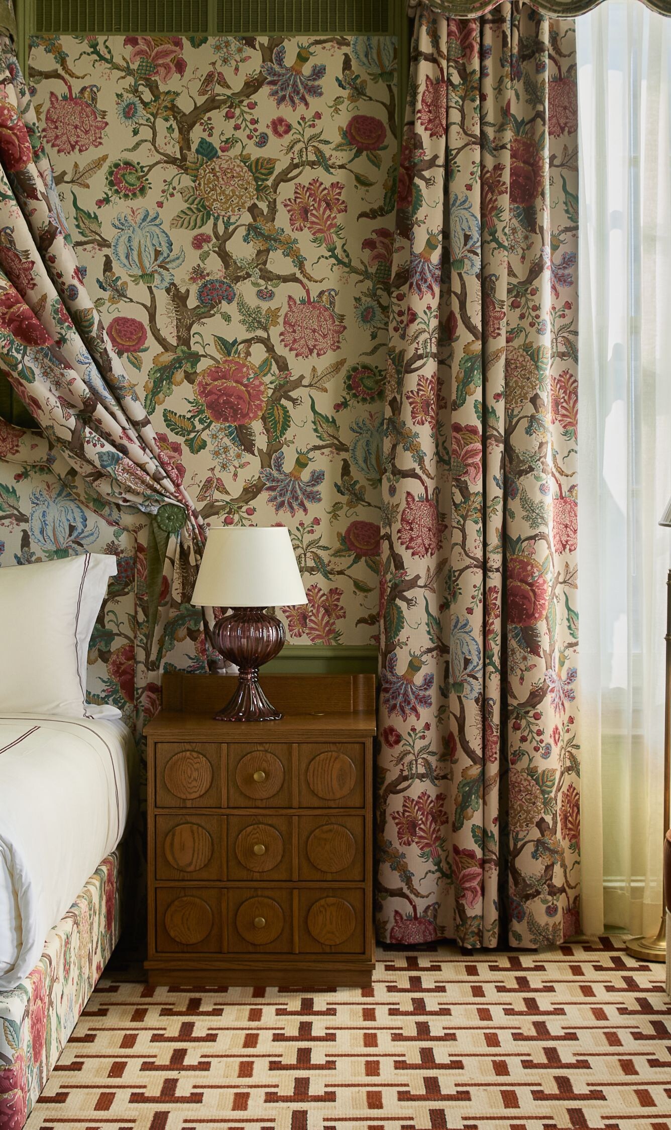 Bedroom with floral canopy bed and seating area