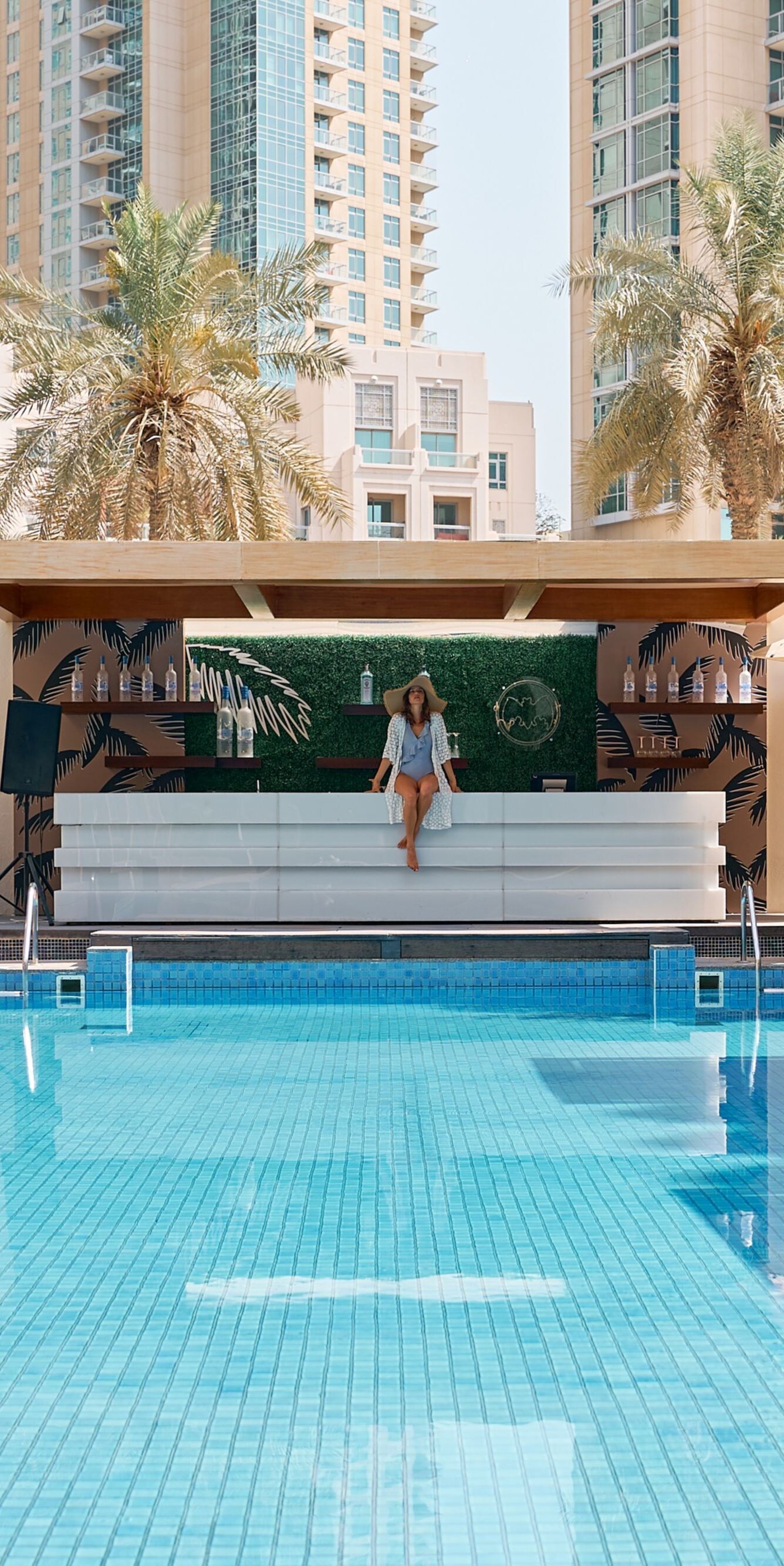 Piscina al aire libre con cabañas y el horizonte urbano por detrás