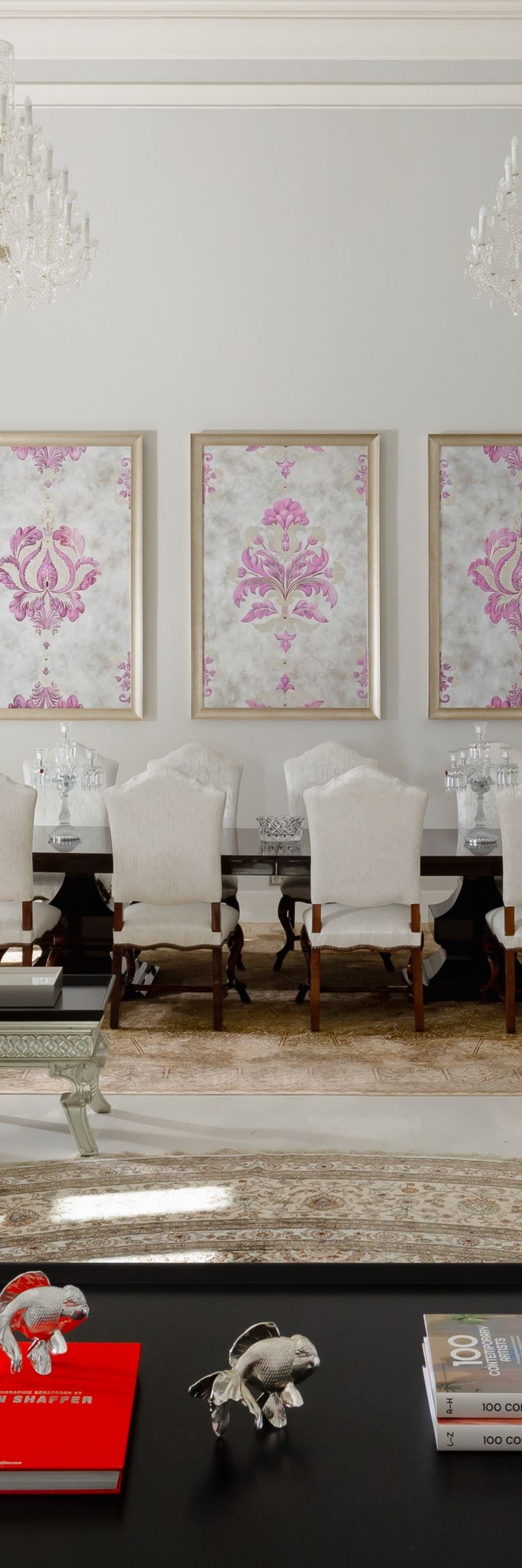 Elegant living room with chandeliers and decor.