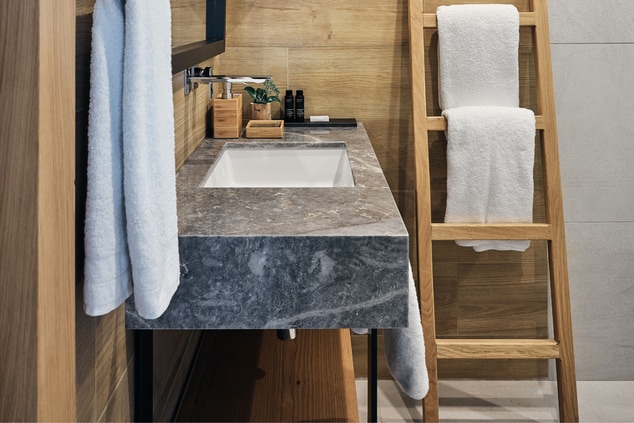 marble sink in bathroom with wooden accessories  