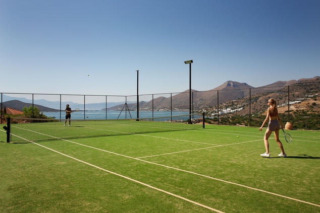 two people playing tennis in a tennis court 