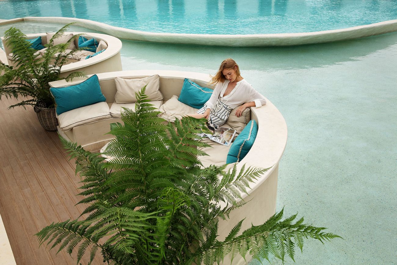 woman sitting on couch by the pool
