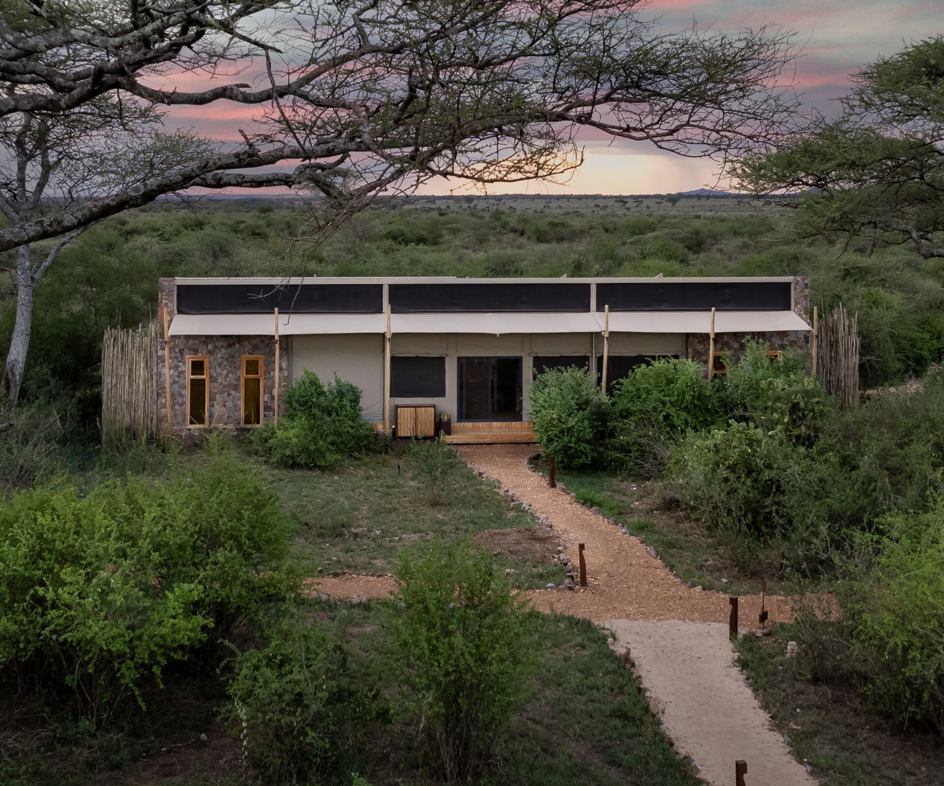Exterior view of a two-bedroom safari tent at dusk