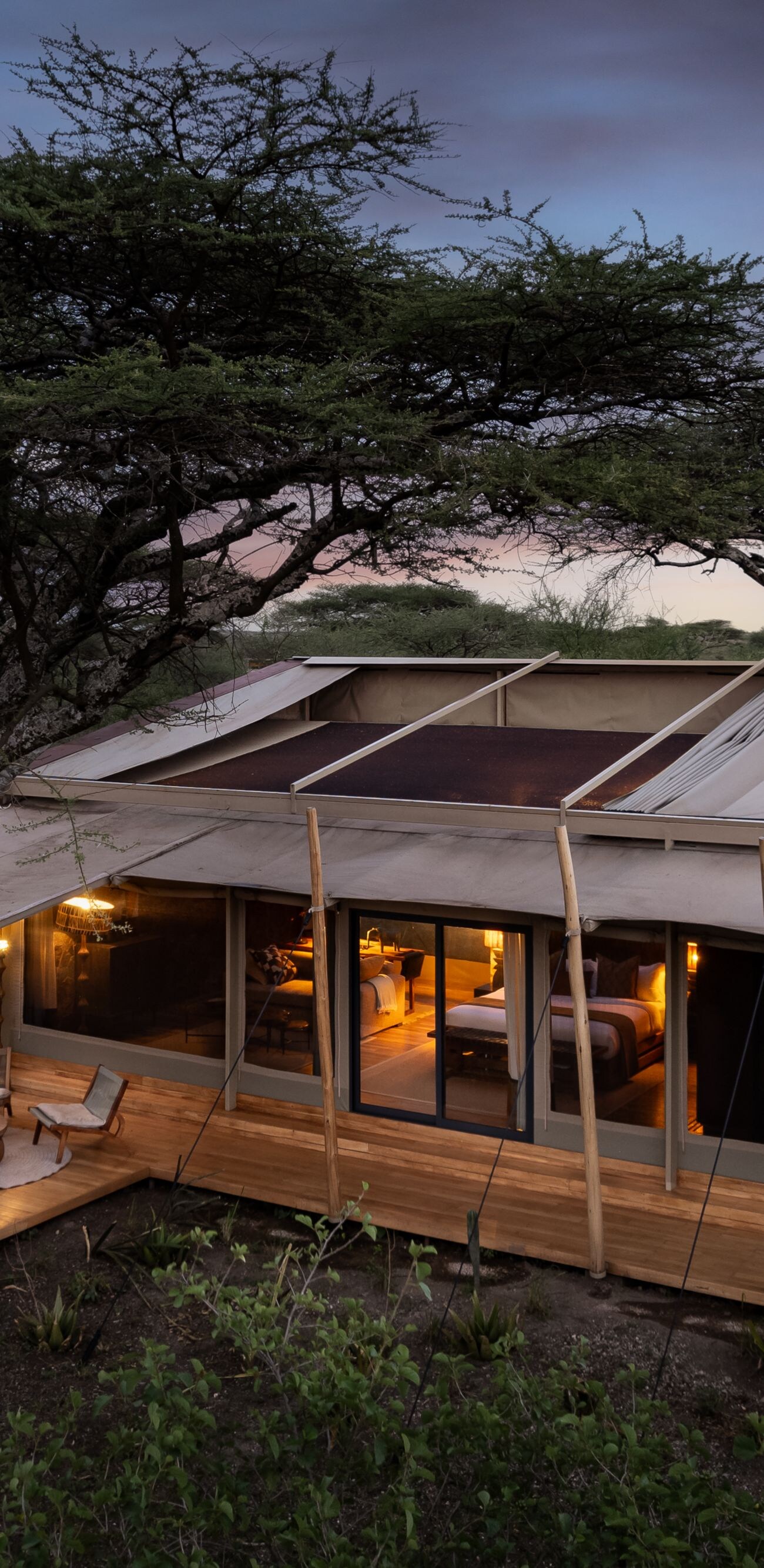 Exterior of a deluxe safari tent surrounded by bus