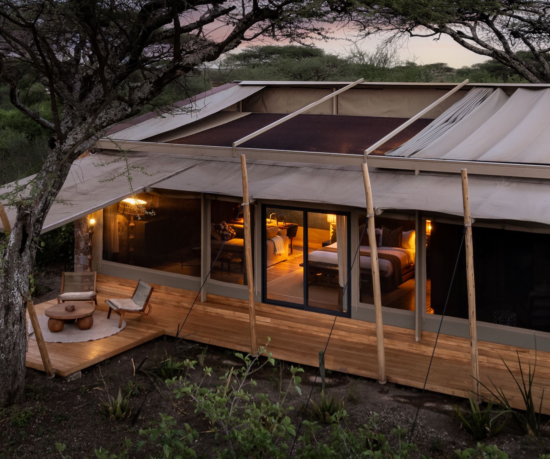 Exterior of a deluxe safari tent surrounded by bus