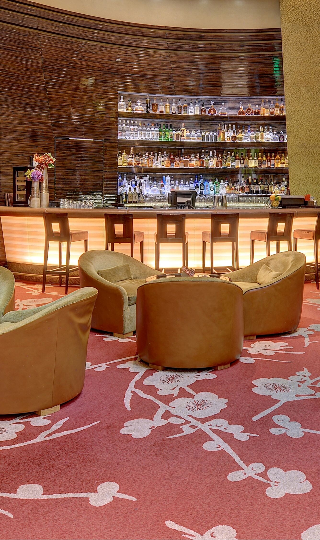 Lounge chairs around small tables, bar