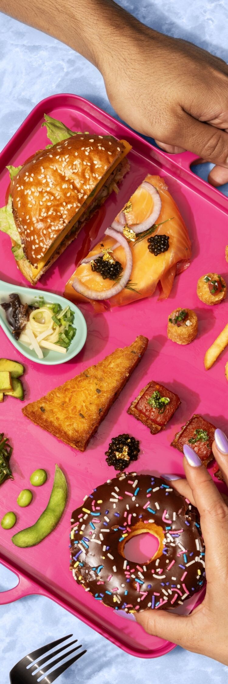 Hands holding pink tray with food on it.