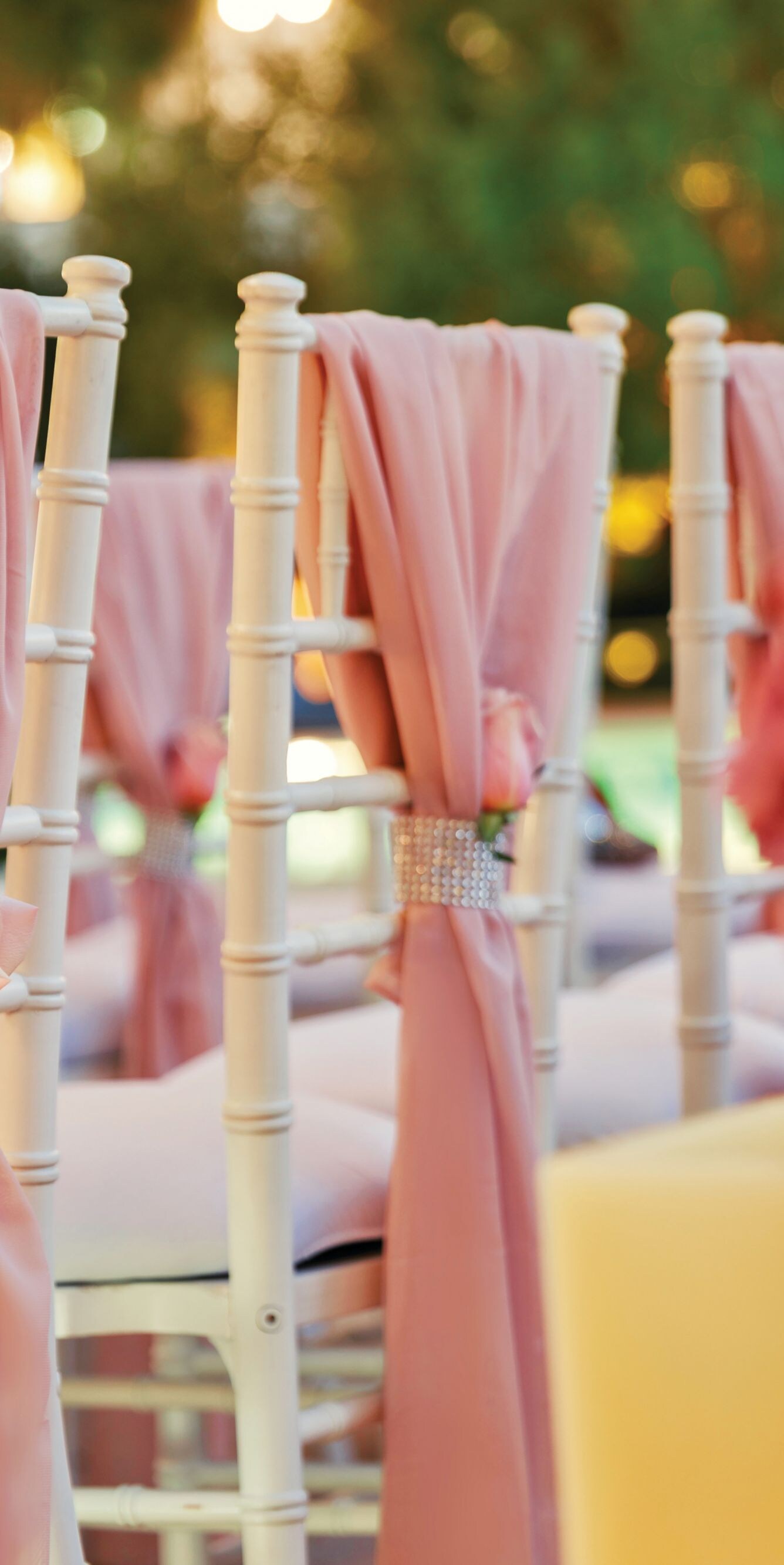 Back of chairs draped with fabric, flowers
