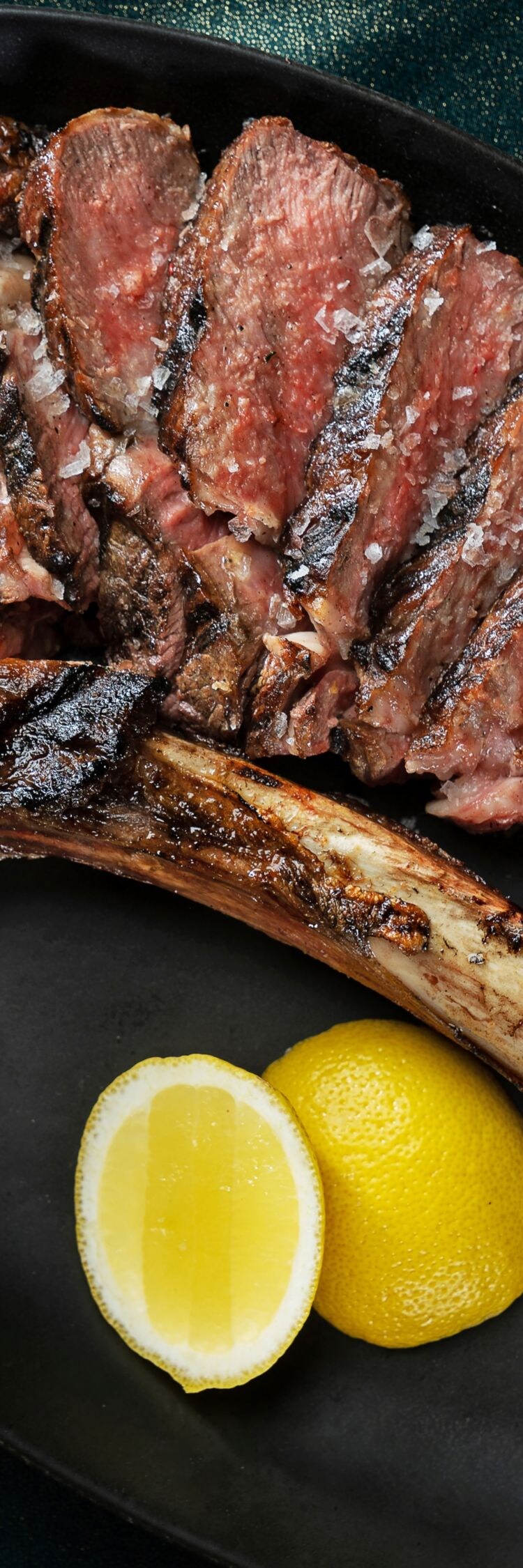Tomahawk steak cut into slices off the bone.