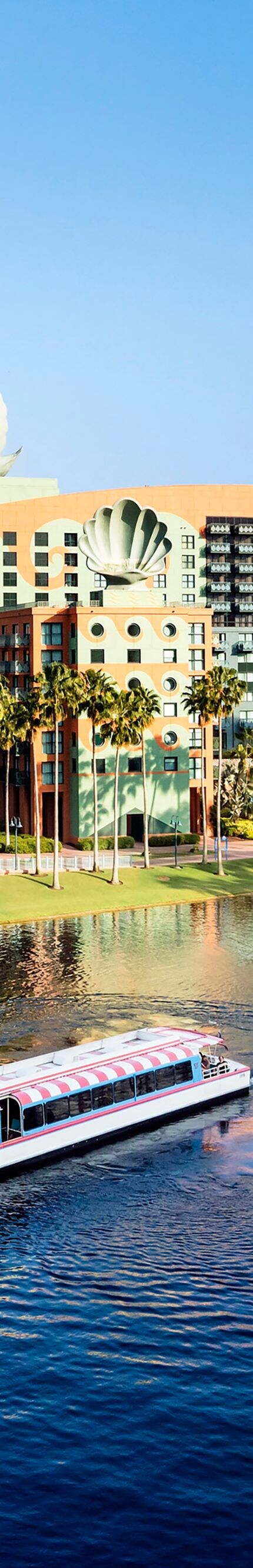 Exterior del hotel con lago al frente y un bote.