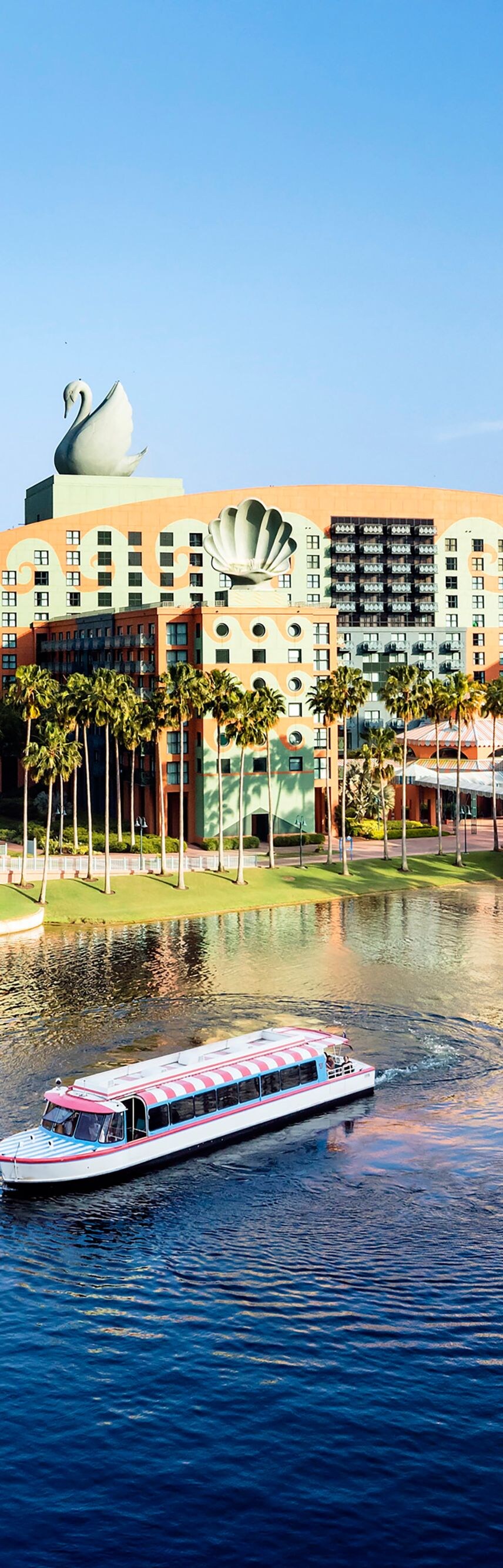 Exterior del hotel con lago al frente y un bote.