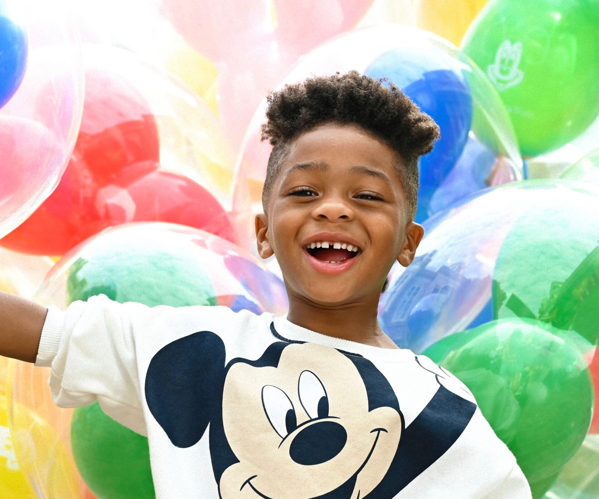 Child holding balloons on Main Street