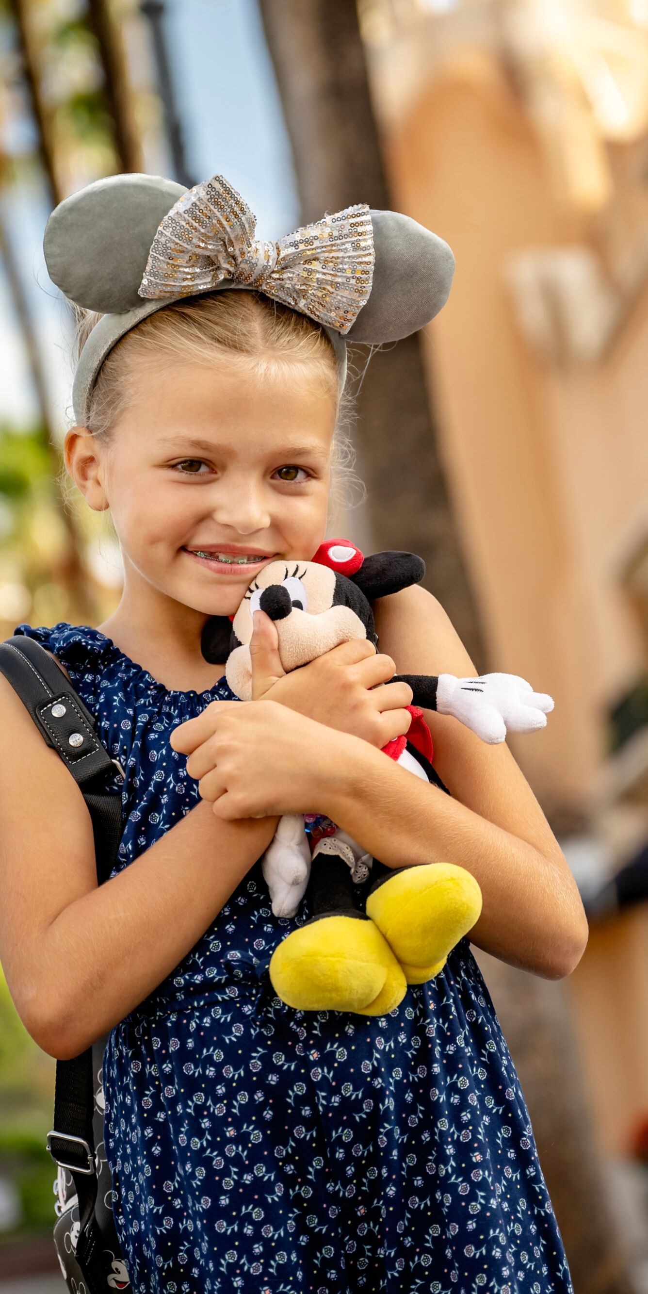 Child with Minnie plush at Disney park