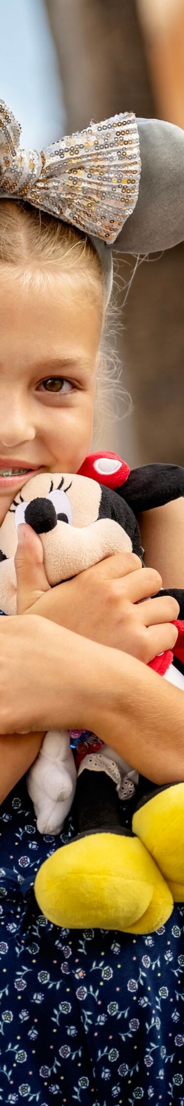 Child with Minnie plush at Disney park