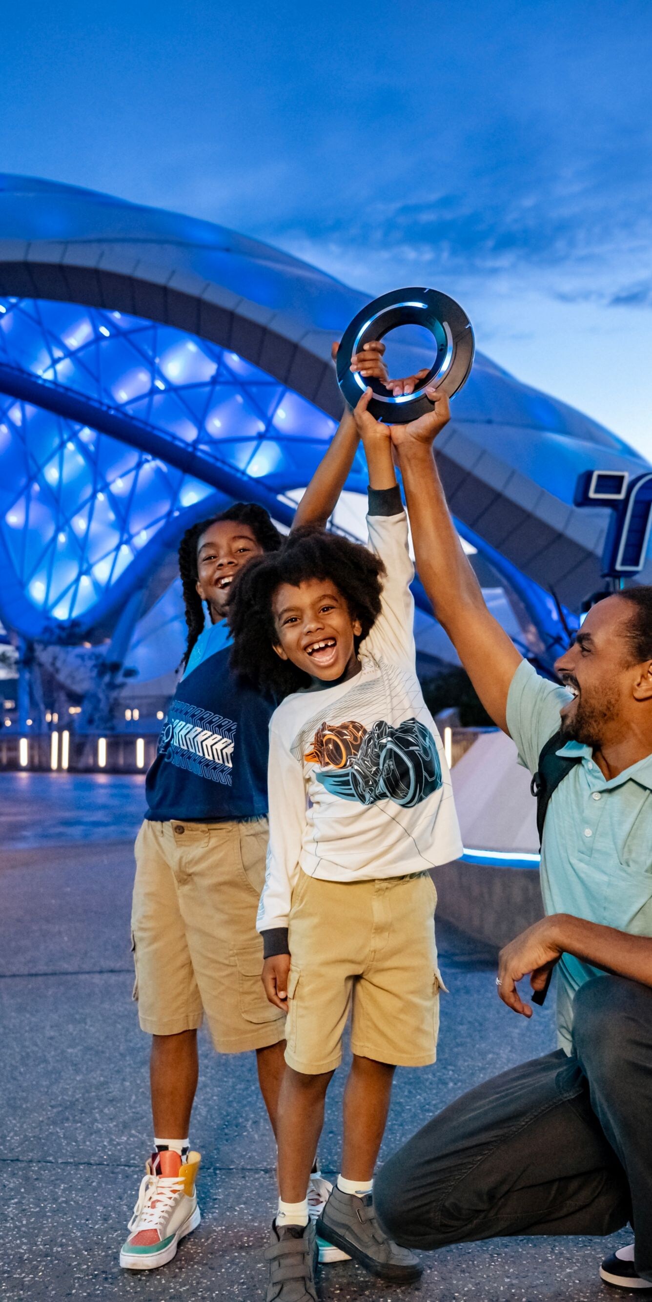 Family smiling in front of Tron ride