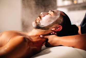Man receiving neck massage in spa