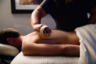 Man receiving spa brush treatment on back