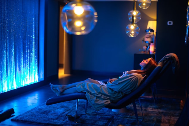 Woman relaxing on a chair in a blue-lit room