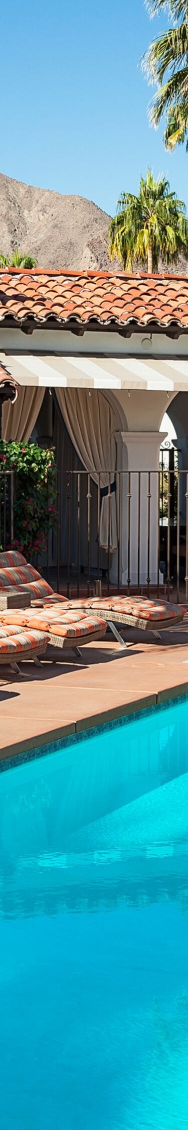 Outdoor pool with lounge chairs and palms