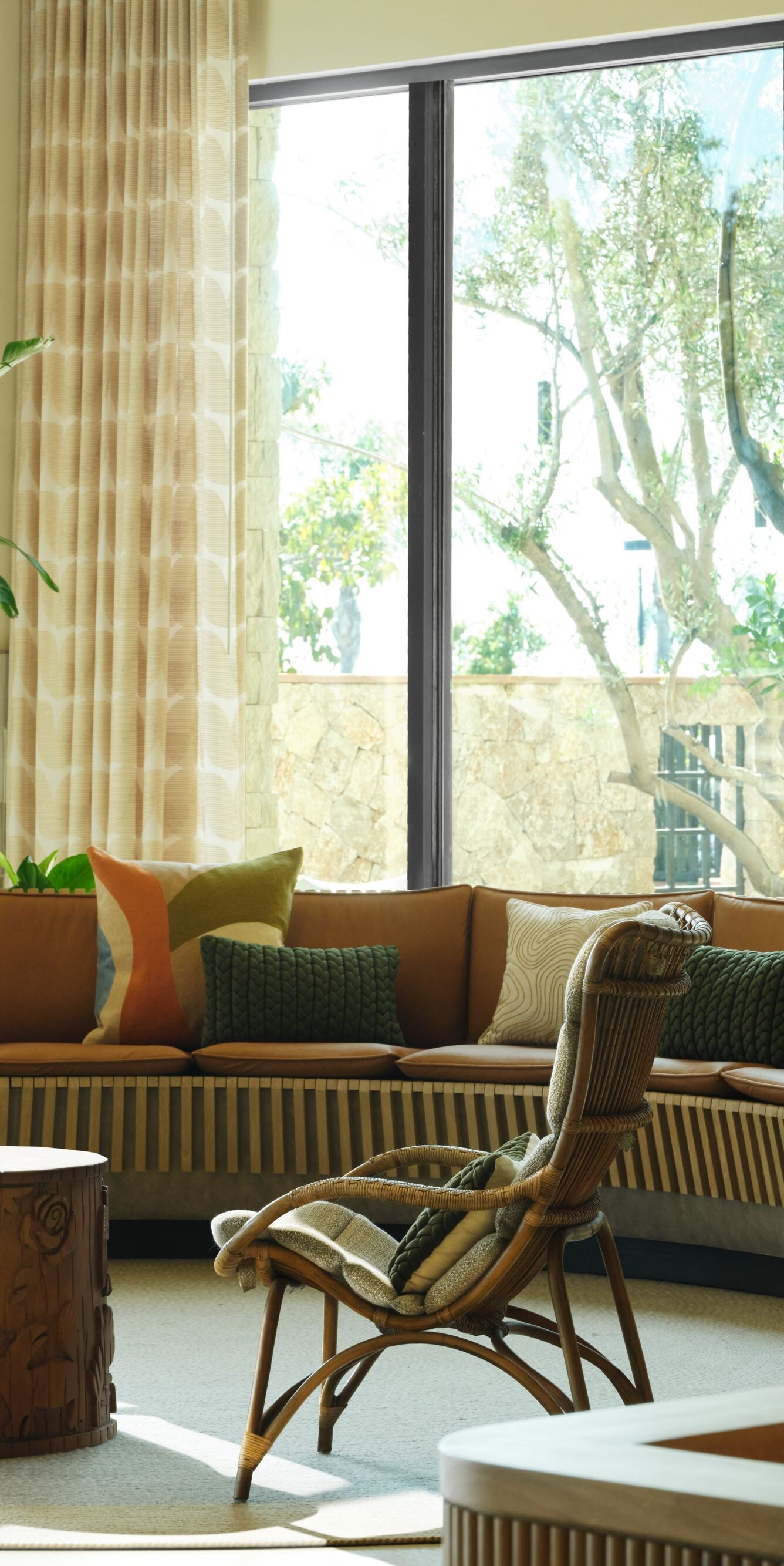 Sunlit lounge with curved sofa and plants