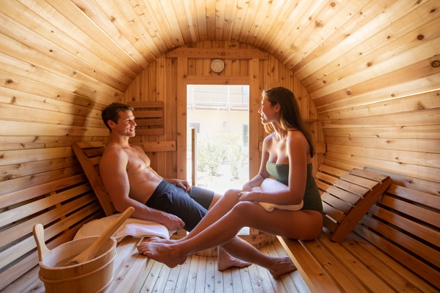 Guests sitting inside barrel sauna relaxing