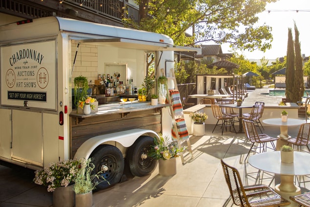 Horse trailer converted to a cocktail bar by pool