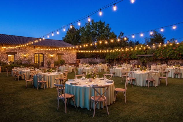 Tables and chairs, lawn, stone building,dinner set