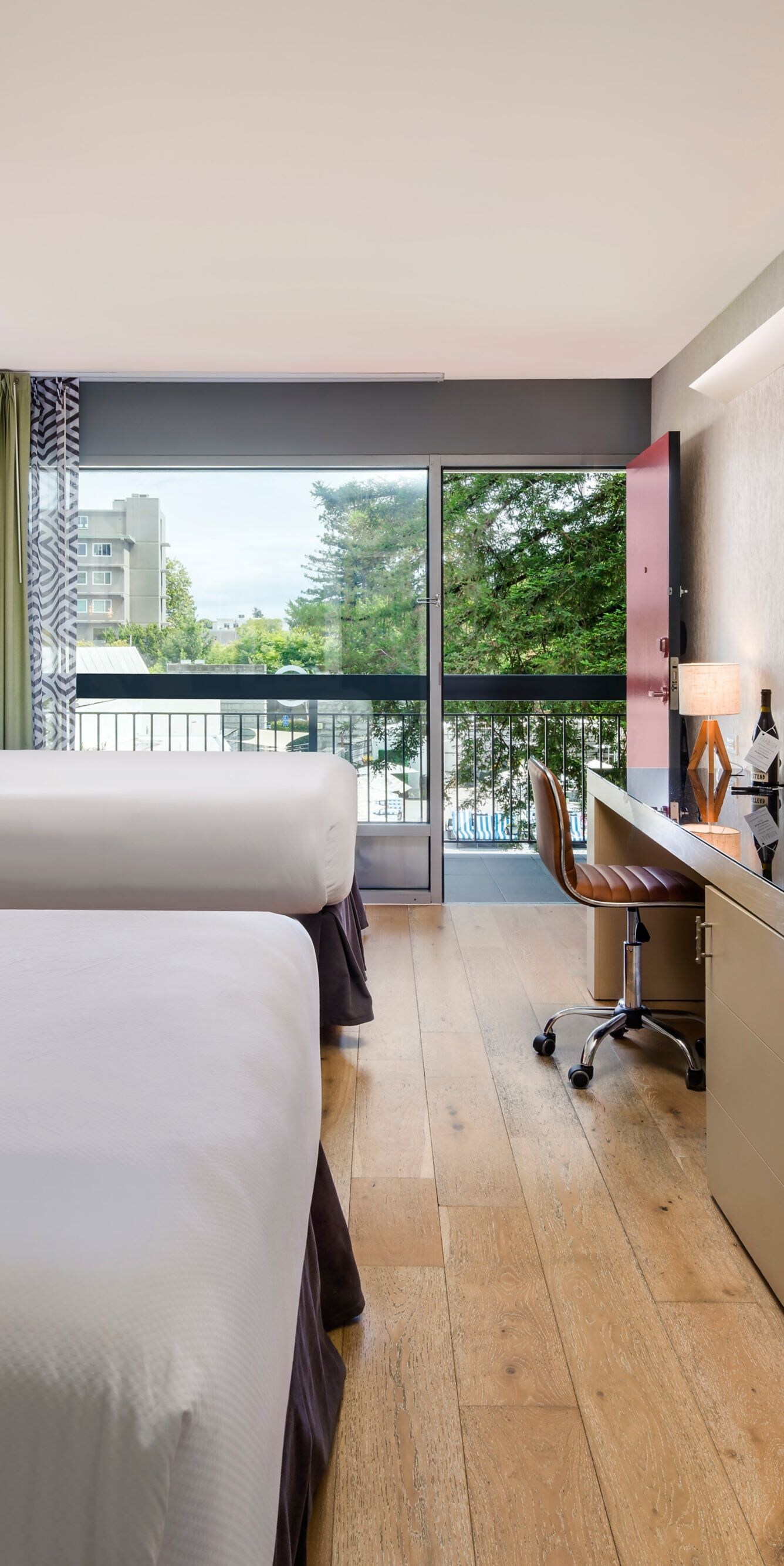 Two queen beds with desk, TV, and balcony