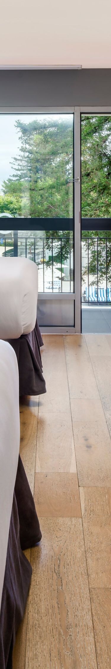 Two queen beds with desk, TV, and balcony