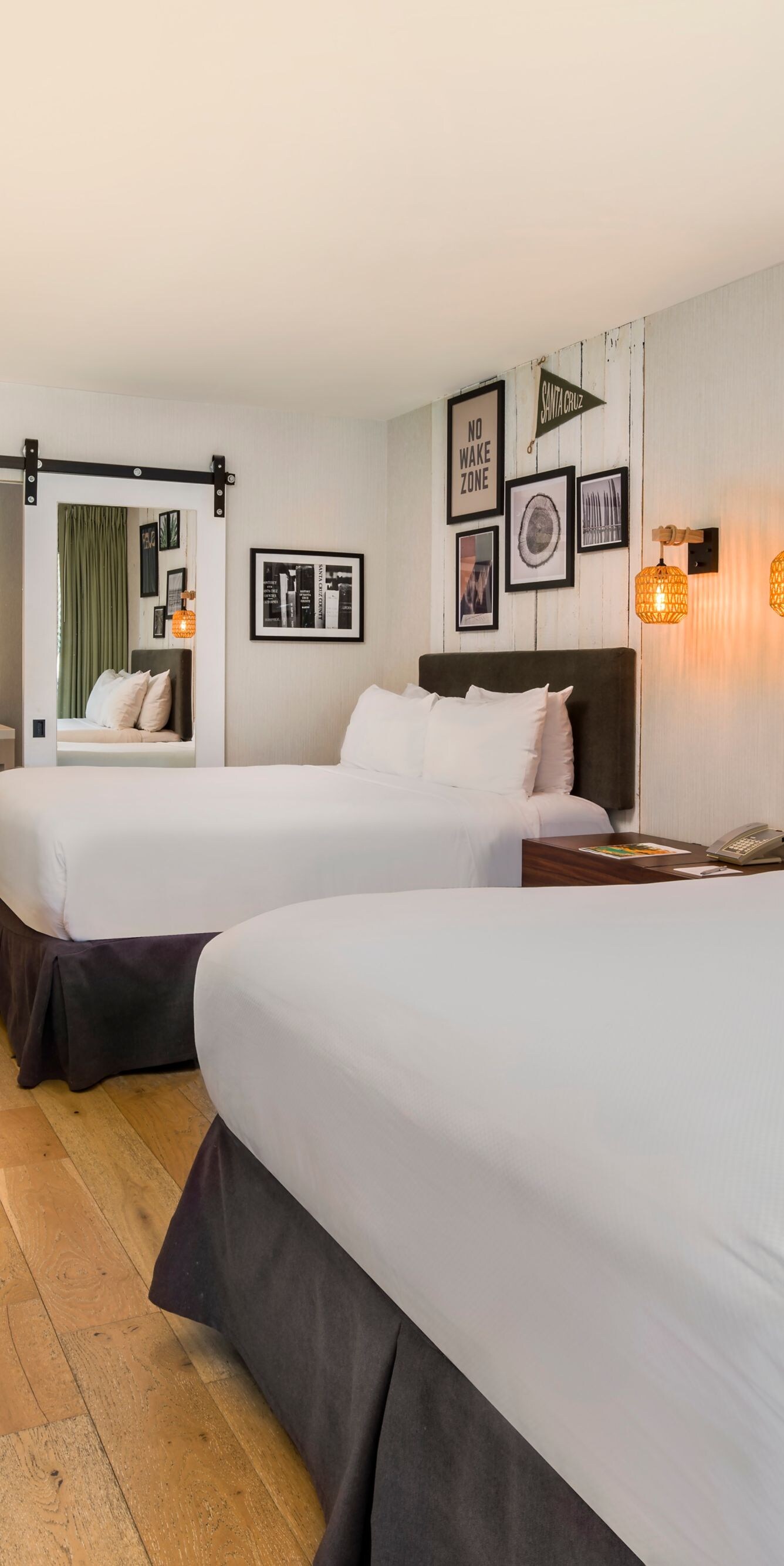 Two queen beds with wall art and desk