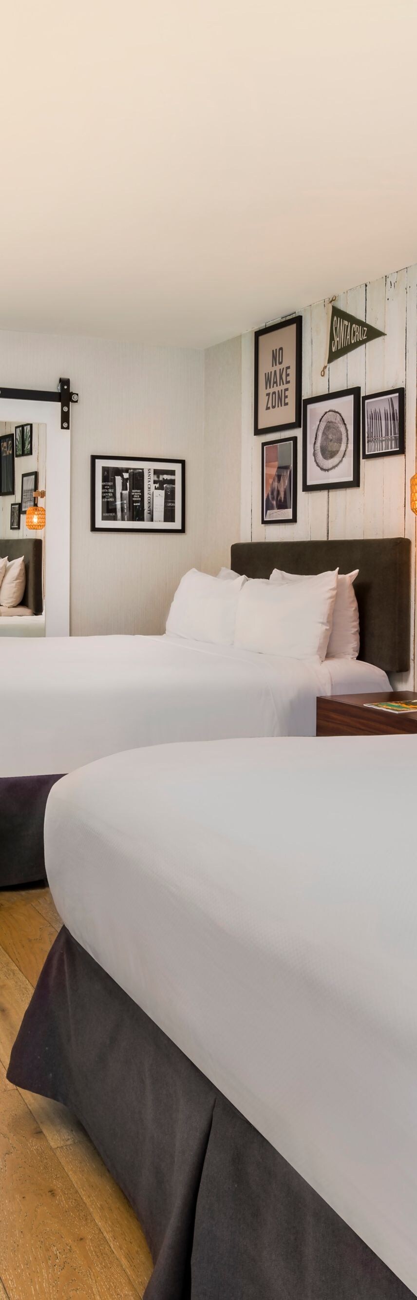 Two queen beds with wall art and desk