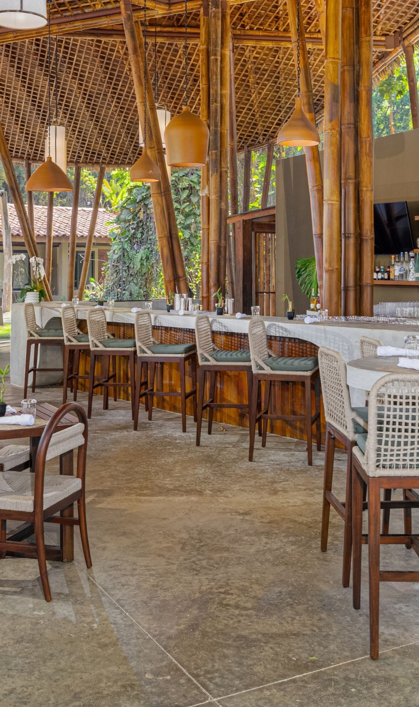 Zona abierta del restaurante con estructura de madera, sillas